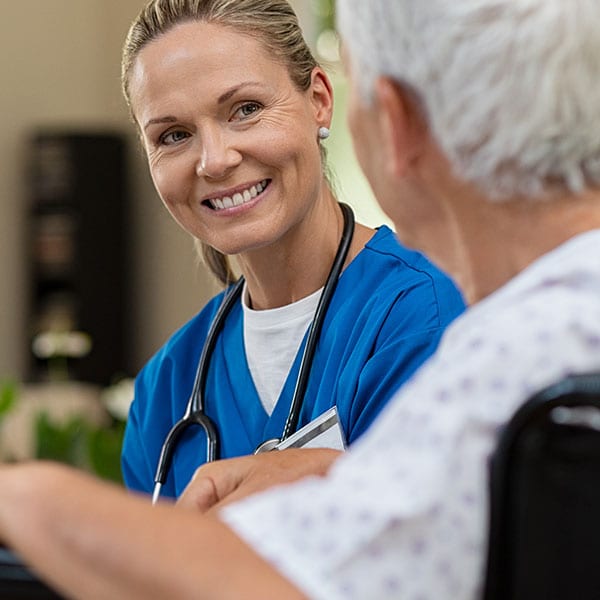 En sjuksköterska som pratar med en äldre patient