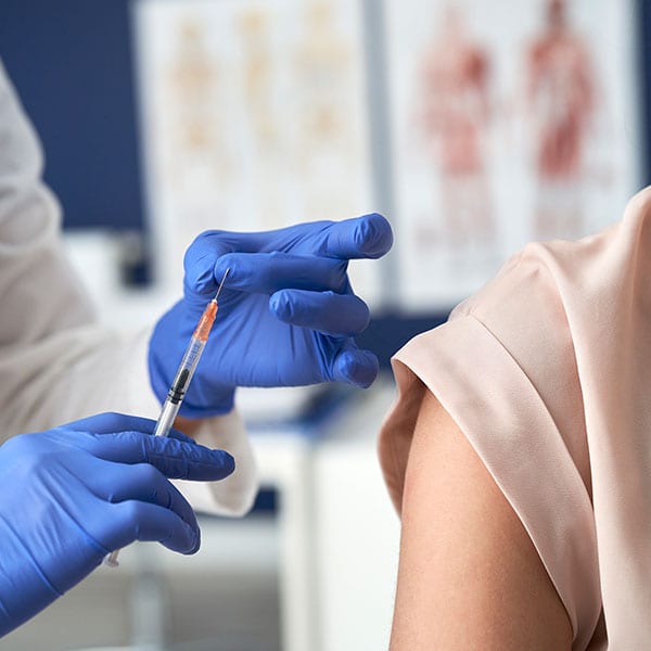 Bilden visar en arm som precis ska vaccineras med covid spruta